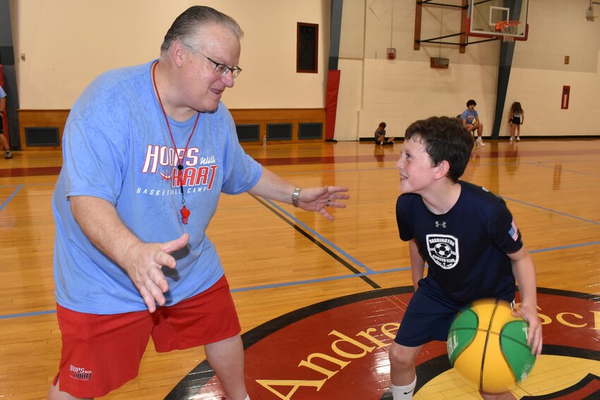 St. Andrew's School head basketball coach Mike Hart (left) plays a little defensive pressure on third grader Henry Tisdale during the recent Hoops with Hart Basketball Camp.