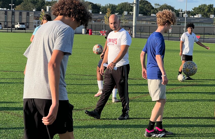 New East Providence High School boys' soccer head coach Tim Calouro (center) looks on as his players perform a juggling drill during a recent practice session Tuesday night, Aug. 22. Calouro, a former standout for the Townies at the turn of the century, takes over the program from former teammate and friend Tony Vieira.