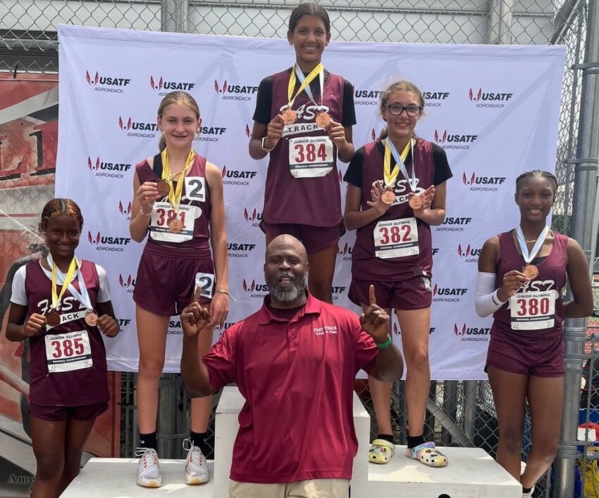 Members of the Fast Track 4x100 and 4x400 meter regional champion relay teams included (left to right) Laejah Preston, Eleanor Lial, Jordin Preston, Caitlin Massey and Serenity Lewis along with head coach Ernest Fennell.
