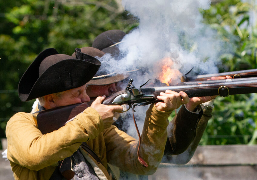 Brain Mello (middle) and other members of Tew&rsquo;s Company, fire off their muskets.