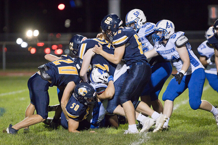 Matt Zimmerman (50), Graham Bennett (52), AJ DiOrio (20) and Ben McClelland (66) smother a Middletown ballcarrier during the first quarter of the Injury Fund game on Thursday night, Aug. 31.