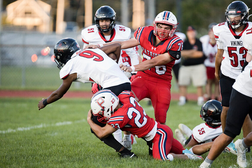 Portsmouth Patriots John Colna and Alexander Lopes (right) stop a Rogers opponent from advancing during an Injury Fund game Thursday night in Barrington.