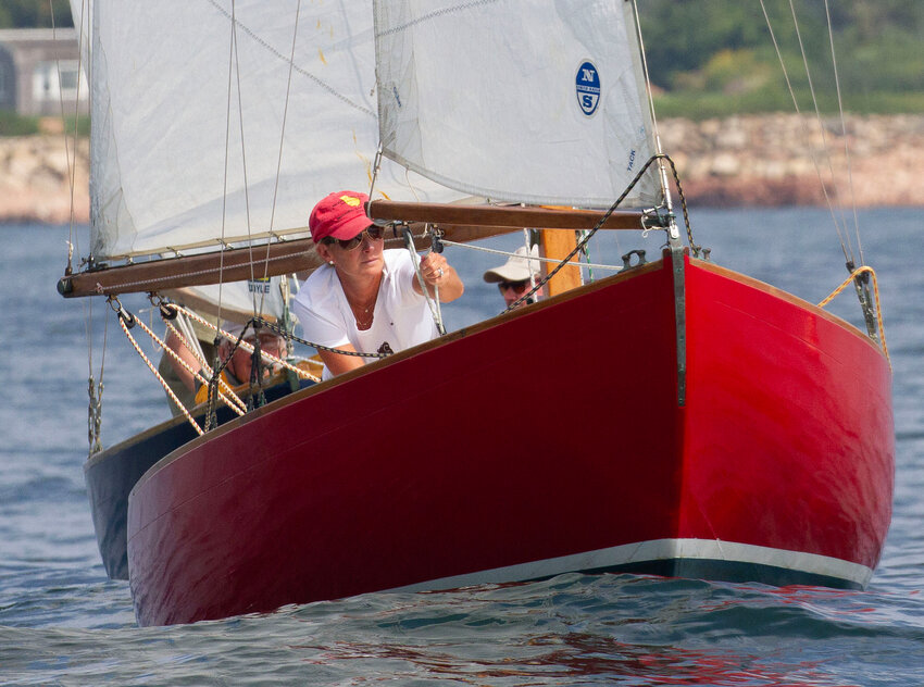 Mara Lozier Shore (left) aboard Elisha, adjusts the sail during a race this month. Shore saved the Alden Sakonnets from disappearing in the early nineties and is a big reason why the boats are still racing today.&nbsp;