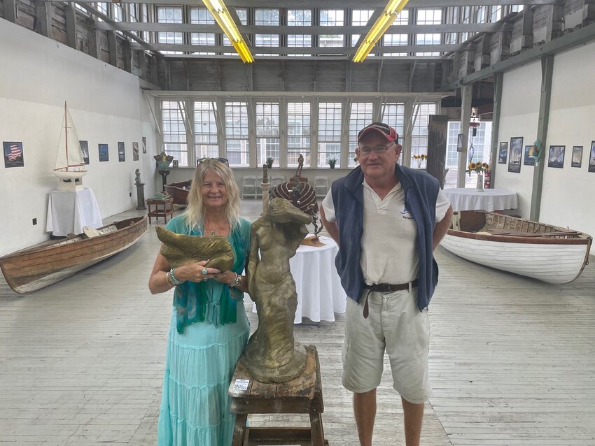 Bonnie Blue and Ed Gifford present &lsquo;Myths of the Sea&rsquo; at Herreshoff Marine Museum thought September. Blue is pictured here holding a figurehead she sculpted for Bristol sailor Donna Lange to take on her second circumnavigation in her boat Inspired Insanity. They are standing next to a sculpture &ldquo;Vigilant&rsquo; by Blue&rsquo;s grandmother Hazel Holloway Rentsch. Giffords photographs adorn the walls, Blue&rsquo;s sculpture is placed throughout, and vintage Herreshoff dinghies and molds complete the space.