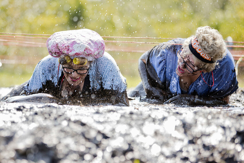 Tracey (left) and Leigh Carney, dressed as &quot;old ladies&quot; make their way through a muddy obstacle during last year&rsquo;s event.