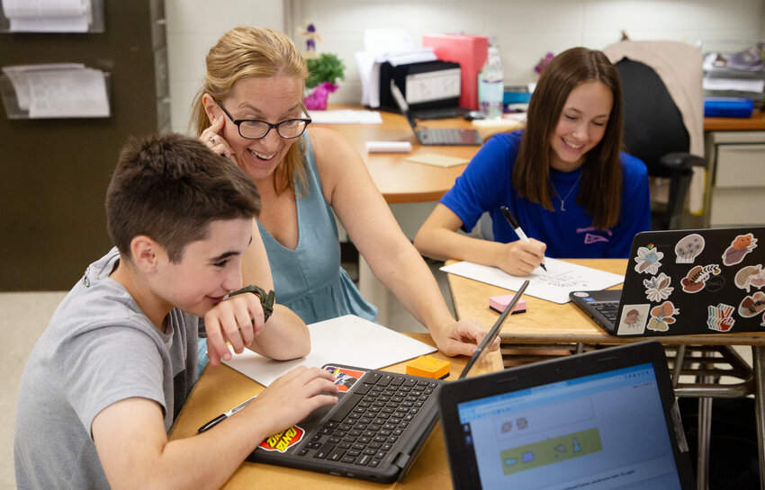 Staci Del Deo works on math with students Elena Silvia (left) and Lily Brawner.