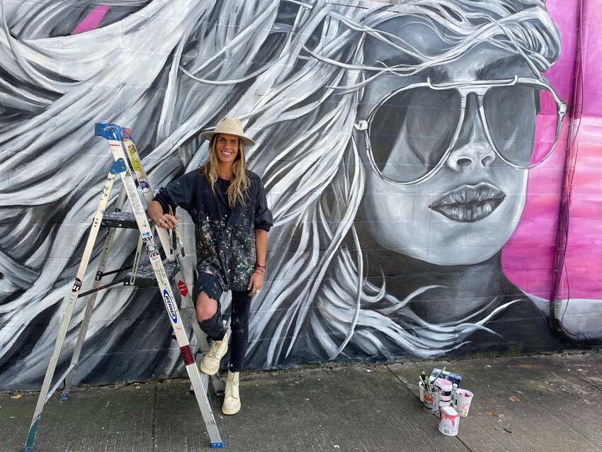 New Hampshire artist Sam Malpass in front of her work, which can be seen on the corner of Hope and Franklin Streets.
