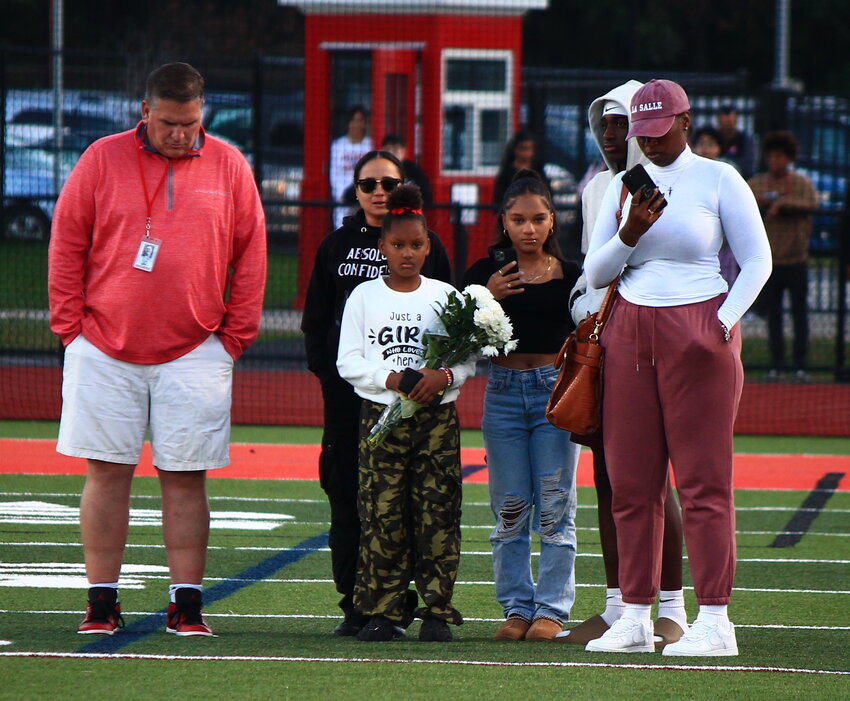 East Providence High School Principal Bill Black (left) leads the family of deceased student C'Anna Ramirez to midfield for a moment of silence before the EPHS football game Thursday, Oct. 5.