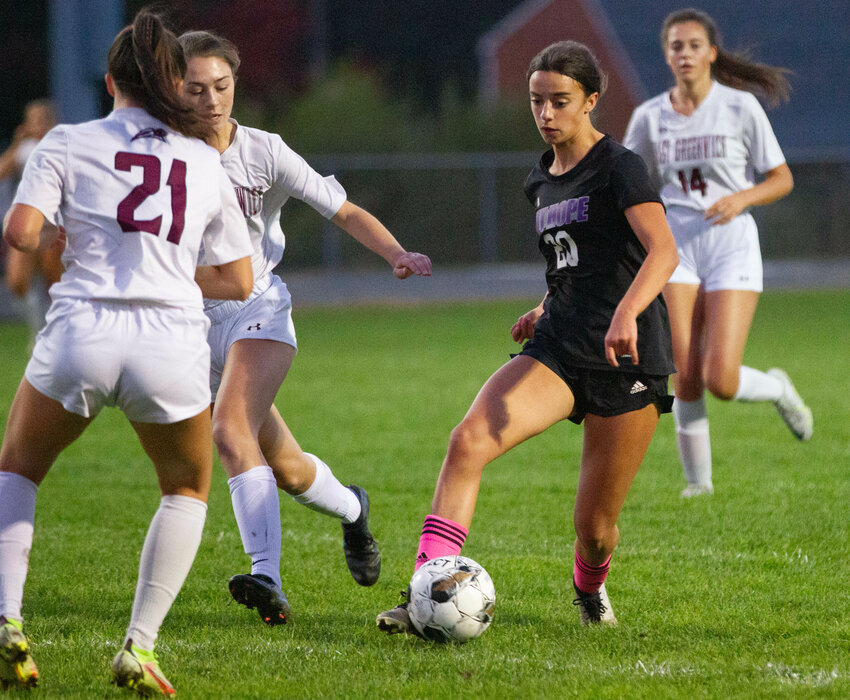 Thea Jackson dribbles through a pair of defenders for a kick on goal in the first half of the Huskies 3-1 win over East Greenwich. She kicked off the scoring in the second half.&nbsp;