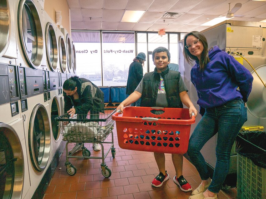 &ldquo;No Wrong Door&rdquo; coordinator Bridget Manning shares a moment with one of the young participants in their &ldquo;Laundry Love&rdquo; program, which hosts free laundry nights, twice per month, for those who need a helping hand.