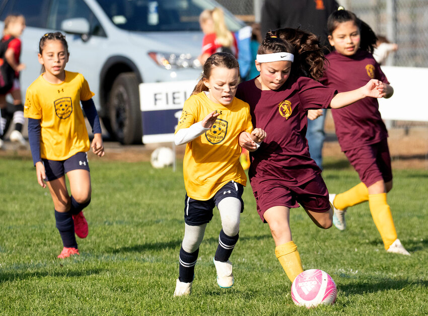 Gwen Green (left) battles an opponent for a loose ball during a game between Barrington&rsquo;s U10 Argentina team and Lenox, Mass. FC at Barrington High School on Sunday.