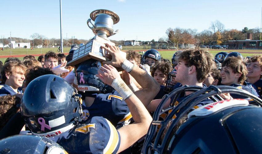 Barrington players hoist the Pierce Donovan Memorial Trophy after winning the Thanksgiving Day game.