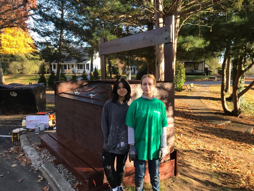 Barrington High School students Sabine Cladis (left) and Emma Pautz stand in front of a new compost drop-off site in town. Pautz said not enough schools are following a law that calls for schools to have lunchroom composting and food donation programs.