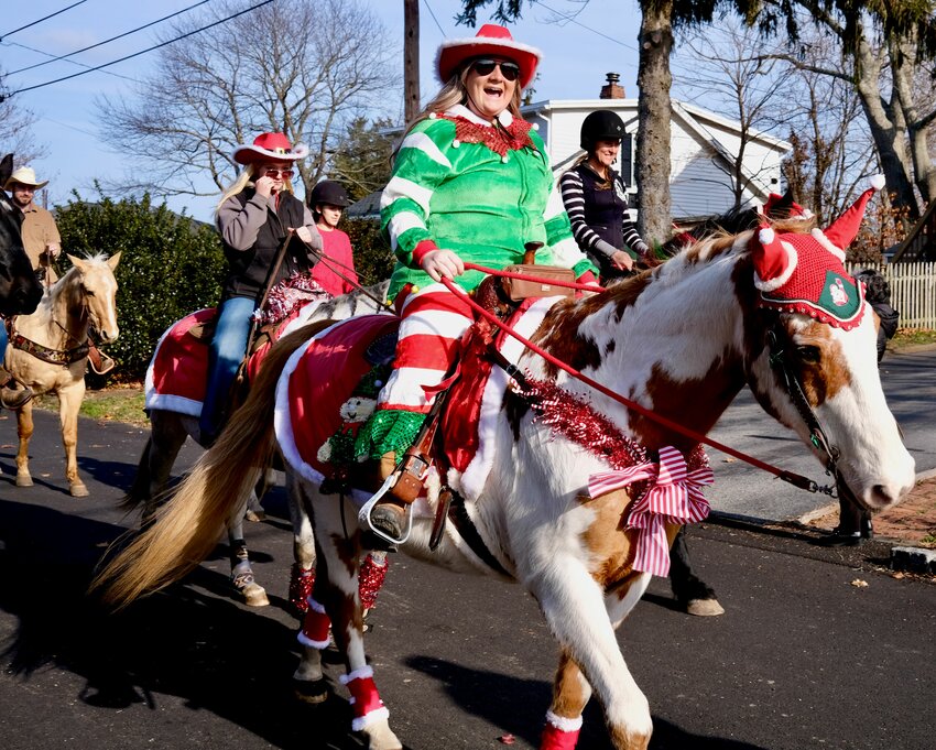 Val Belliveau, on her horse Peppy, rides through the streets of Common Fence Point on Saturday during the annual Caroling by Horseback event. The rider behind her at left is Elizabeth Lantz.
