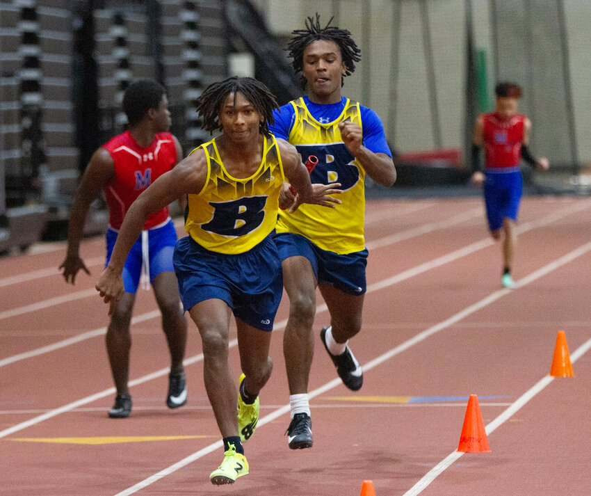 Charley Potter (right) hands the baton off to his the brother Chucky during the 4x200-meter relay race during a meet at the PCTA on Monday.