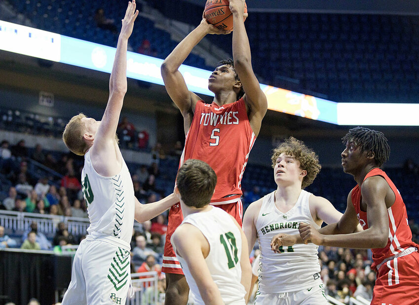 Kenaz Ochgwu takes a jumper between a pair of Bishop Hendricken defenders during last season's Open State Tournament semifinals. The 6-foot-7 senior leads the cast of returning players to the East Providence High School boys' basketball team this winter.
