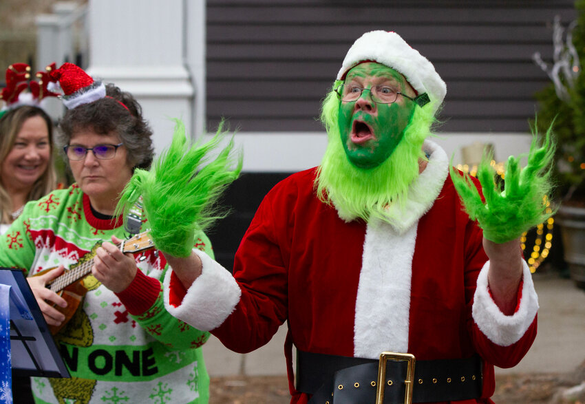 Jonathan Keller portrays the Grinch during a performance by the Unlikely Strummers on Hope Street.