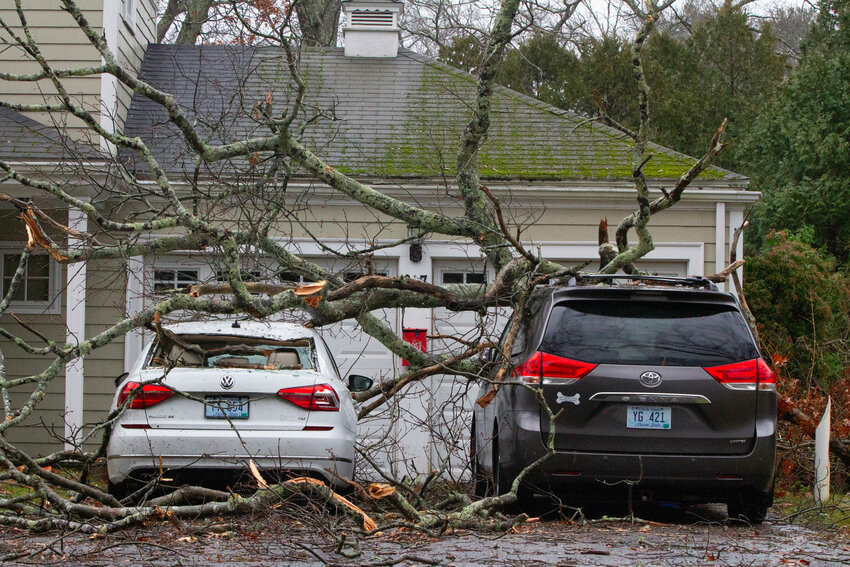 A tree branch sits atop two vehicles parked outside a New Meadow Road home in Barrington on Monday morning, Dec. 18.