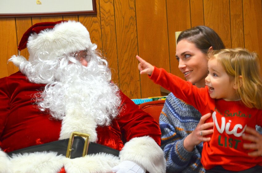Two-year-old Sophie Staudinger, accompanied by her mom, Chelsea Moran, was ecstatic at meeting Santa (Cup Defenders Association President Steve Cavalieri) for the first time.