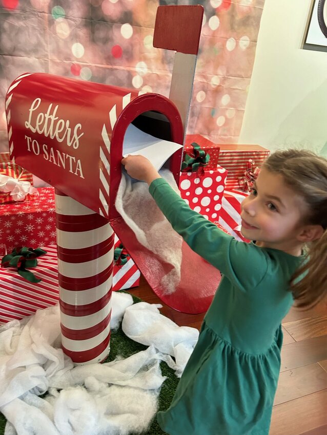 Five-year-old Lizzy, from Portsmouth, mails a letter to Santa at the Newport Car Museum on Saturday during the Four Hearts Foundation&rsquo;s second annual &ldquo;Santa Claus for a Cause&rdquo; fund-raiser.