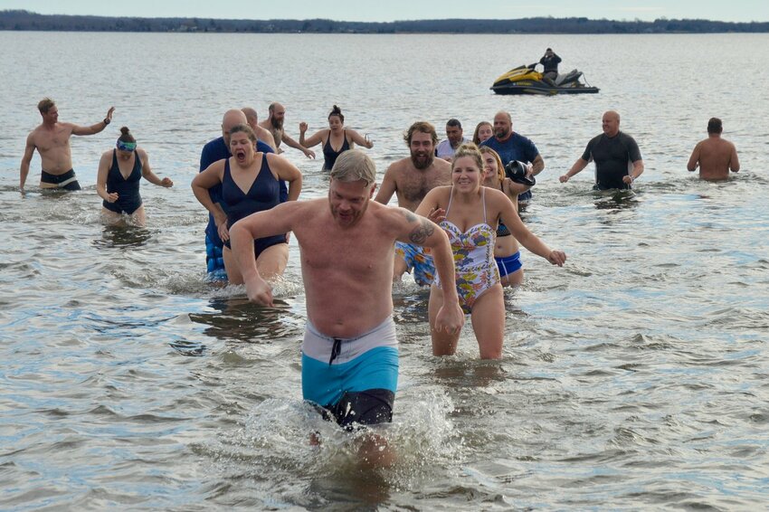 Polar divers scamper out of the water at Island Park Beach on Jan. 1 of this year. They&rsquo;ll be running back in at noon sharp on Monday.