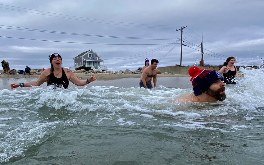 New Year&rsquo;s Eve Day plungers, including Jen Potter of Gnome Surf at left, run for the ocean just after 10:30 a.m. Sunday.