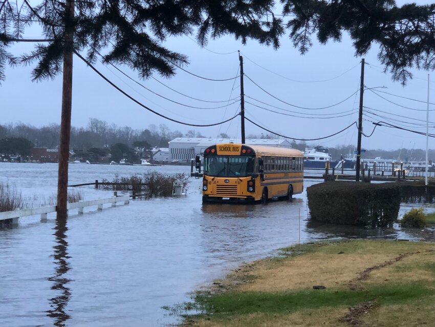 A Barrington resident captured this photo of a local school bus trying to make morning pickups along a flooded-out Mathewson Road.