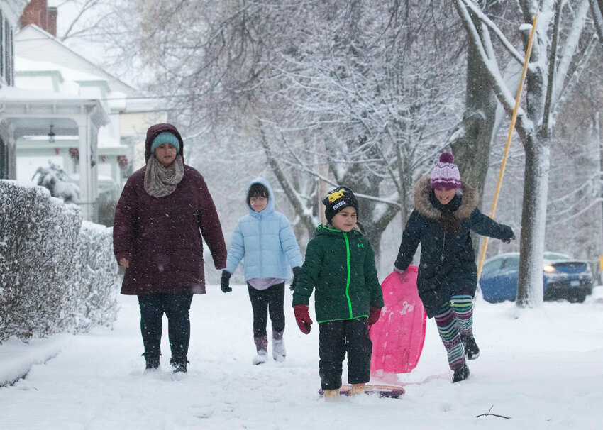 Alyssa Brown (left) Samantha Vento, 10, Jackson Brown, 5, and Sofia Brown, 9, walk down the Bradford Street sidewalk looking for a place to go sledding on Sunday afternoon.