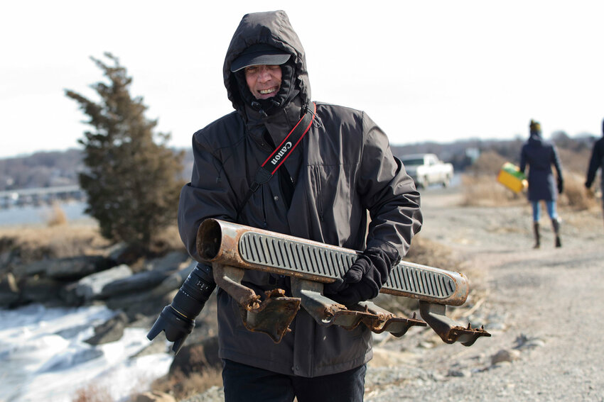 Hugh Fanning hauls a large, rusted car part toward the trash collection pile during a Clean Ocean Access (COA) beach cleanup at Gull Cove in Portsmouth back in February 2019. According to COA, the organization&rsquo;s cleanups &mdash; nearly 2,800 of them &mdash; removed more than 160,000 pounds of debris from local shorelines.