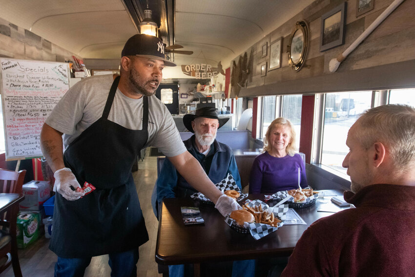 Michael Durrett, head chef and business owner of Dashing Dan&rsquo;s Cafe Car, serves a birthday lunch last week to Bob Obara (in hat), along with his wife Patty and their son, Michael.
