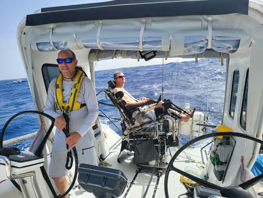 Bristol resident Kenneth Madsen takes the helm while Captain Anders Lehmann enjoys a sunny and breezy day crossing the Atlantic.