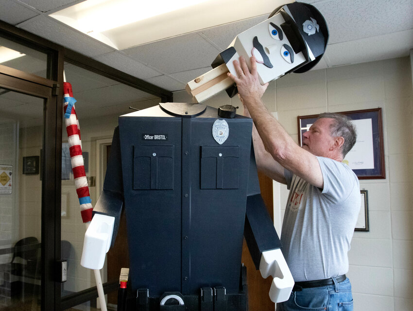 Tom Simeone of Falmouth, Mass., creator of Officer Bristol, adds the finishing touch to the over-7 foot tall figure. Simeone has completed nearly 30 such figures for departments throughout Cape Cod.