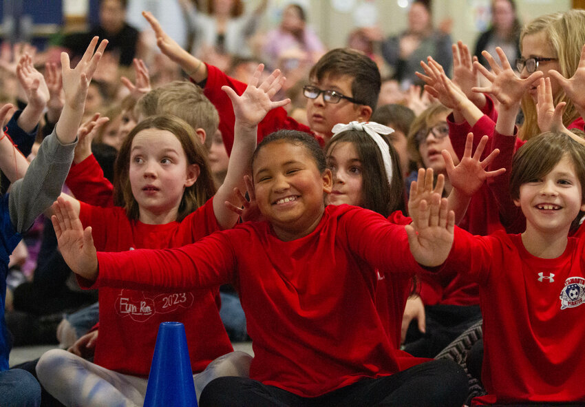 Zoe Suter, Mia Gilling and Charlie Bartlett (from left) from Skylar Ellison&rsquo;s third-grade class &ldquo;dance&rdquo; while sitting as they use hand movements to act out a song.