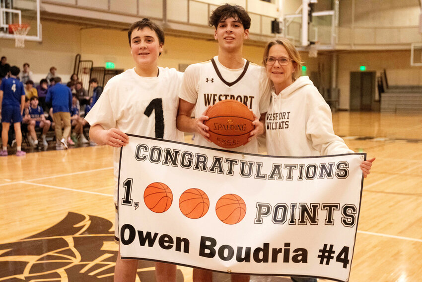 Cole Boudria (left) his older brother, Owen and their mom, Susan Boudria, pose for a photo after Owen scored his 1000th&nbsp;point.&nbsp;