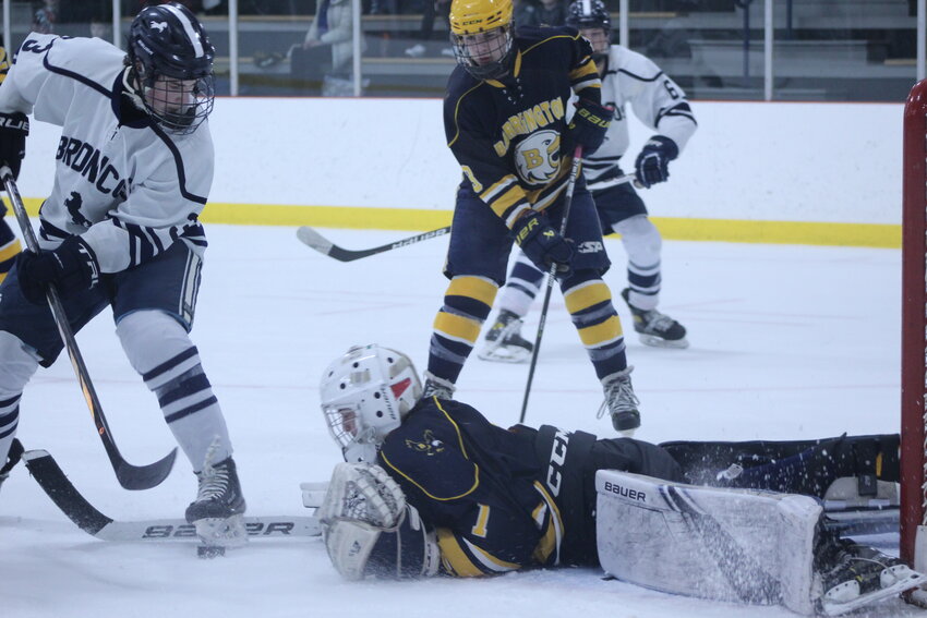 Barrington goaltender Cam Siwik dives out to try to cover up the puck while a Burrillville player looks to get his stick on it. Siwik finished the game with 29 saves.