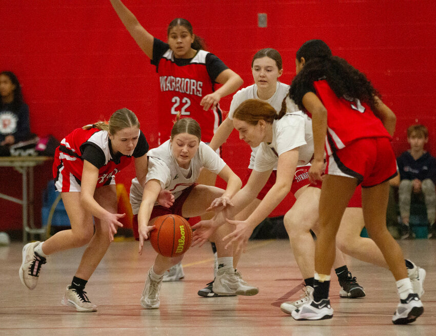 Portsmouth Middle School player Hannah Pilotte (left) steals the ball from a Thompson player, with teammates Greyson Helie and Haley Hurd (right) in on the action. Portsmouth were victorious, 38-31, to win the Eastern Division title.
