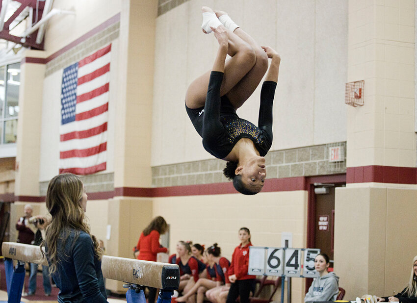 Barrington High School&rsquo;s Adrienne Kollie dismounts from the beam. She earned a team high of 9.00 on the event.
