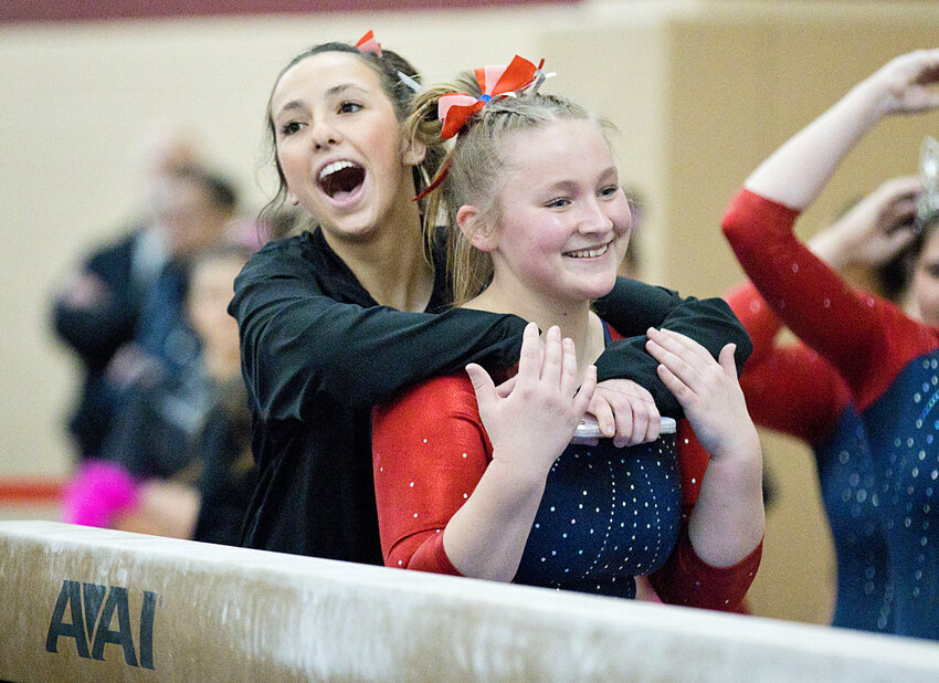 Portsmouth High&rsquo;s Rowan Snyder (left) hugs teammate Kiley Wordell after the latter&rsquo;s 8.25 performance on beam. Snyder led her team with 36 points in the all-around competition, the fourth-best score in the entire state.