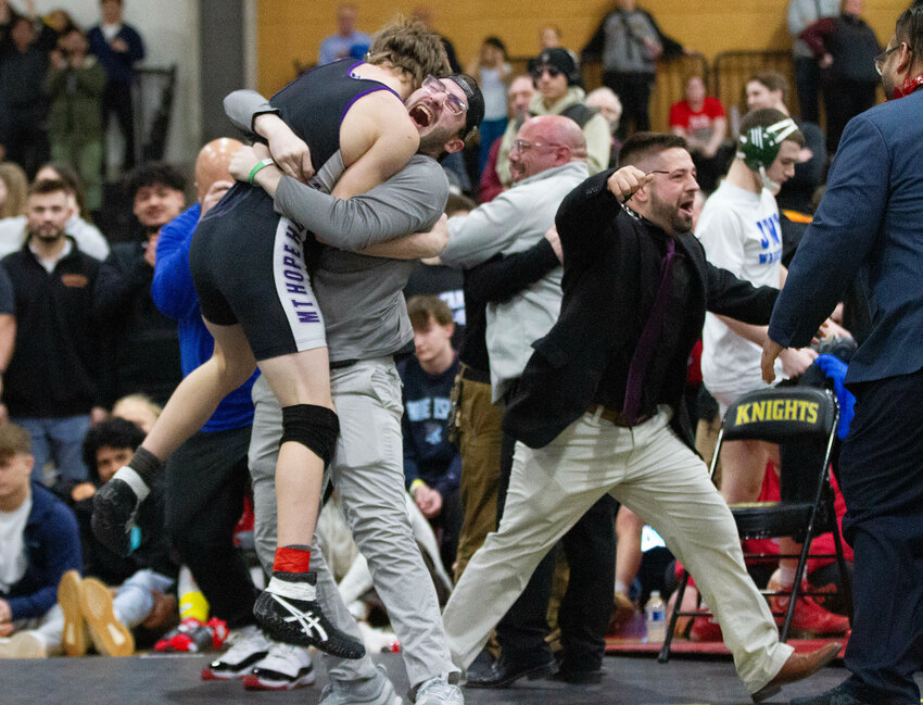 Mt. Hope coach Trevor King lifts Andrew McCarthy into the air in celebration with Dougie Sampson and Ryan Fazzi (right) after McCarthy defeated Colby Vital in the 144-pound finals.&nbsp;