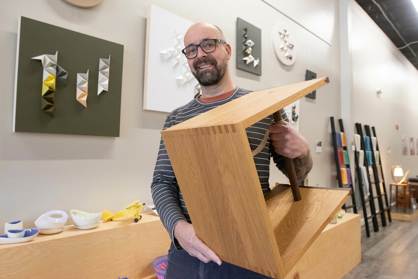 Torsten Mayer-Rothbarth, who opened Inhabit at 450 Main St. (formerly Space Cadets), holds up a piece of wood furniture that he made by hand. Along with being a skilled woodworker himself, he has forged relationships with many artisans, whose handmade items are displayed elegantly throughout the shop.