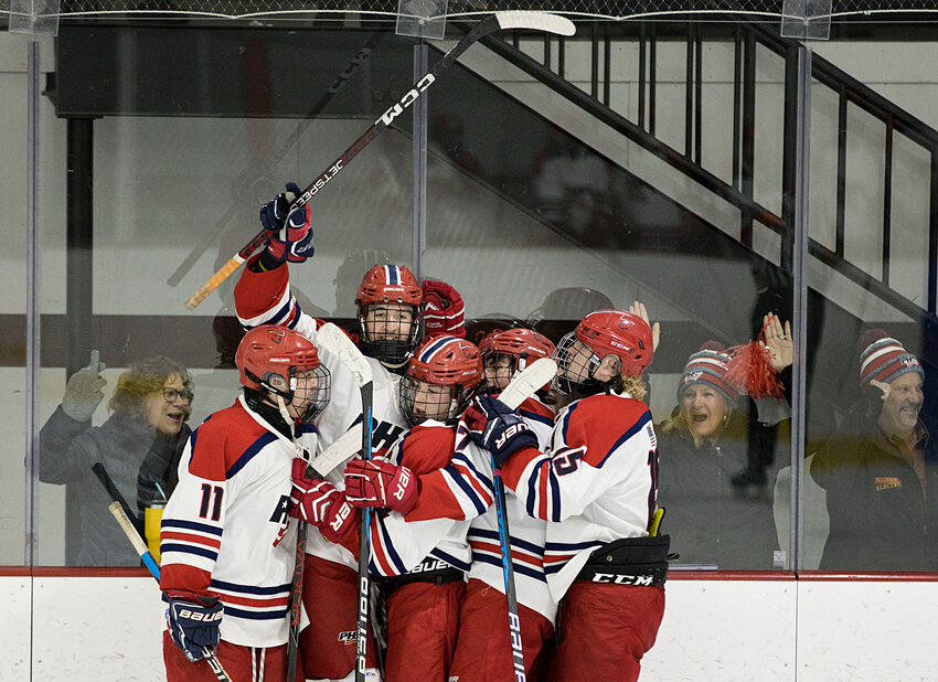 The Patriots surround Dan Biello (second from left) after he scores a goal against West Warwick in game two of the Division II quarterfinals on Saturday. Portsmouth won that game, 5-3, to even the series at one game apiece, and then won the deciding game on Monday.
