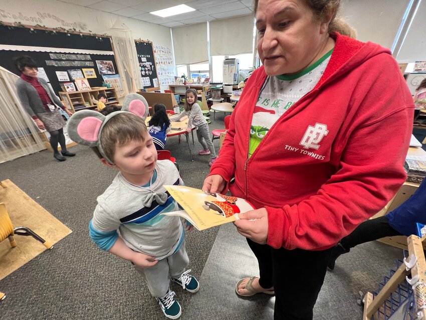 East Providence Pre-Kindergarten Principal Karen Rebello checks out a book with one of her pupils during &quot;Reading Week&quot; at the Oldham Early Learning Center.