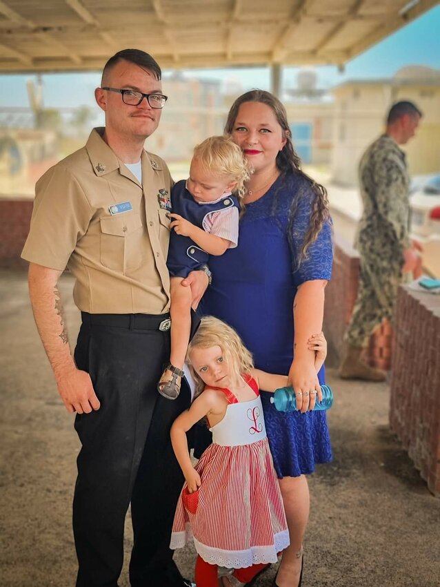 Kathryn Weaver, alongside her husband, Petty Officer 1st Class George Weaver of the United States Navy, and their two children.