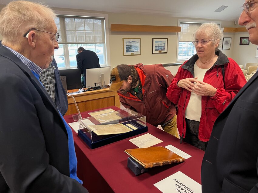Residents view The Portsmouth Compact of 1638 and other artifacts during Founding Celebration held Thursday at Portsmouth Town Hall. They are framed by Town Historian Jim Garman (left), and Town Council Vice President Leonard Katzman.
