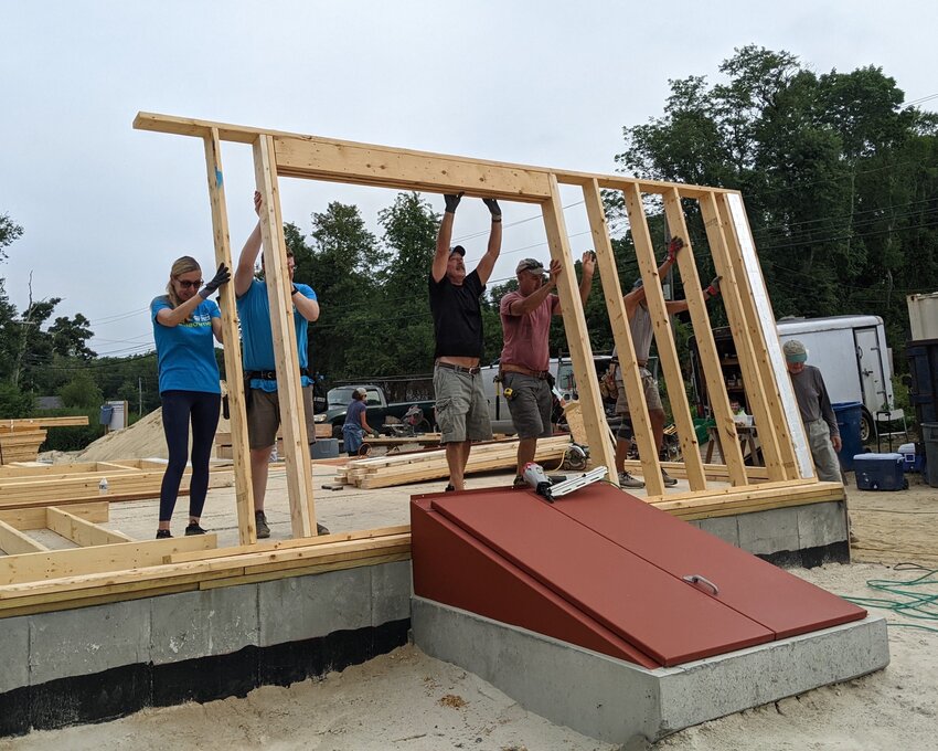 Holly (left) works with volunteers to frame up a wall in this photo taken in August 2022.