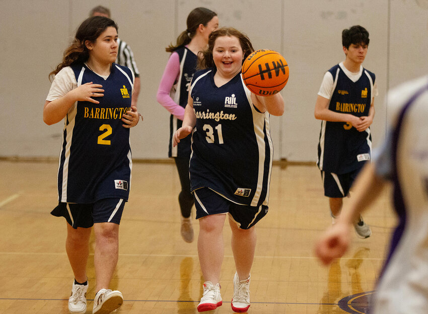 Izzy Dente (left) looks on as Julia Burke dribbles up court during the recent Unified Basketball game between Barrington and Mt. Hope.
