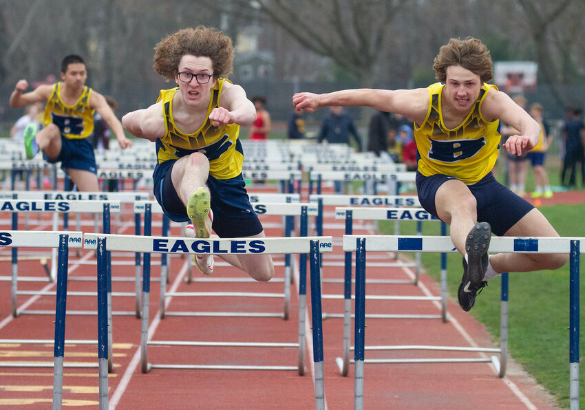 Grady Hazlett (left) and Ryan Martin race toward the finish line in the 110-meter hurdles during Monday&rsquo;s track meet.