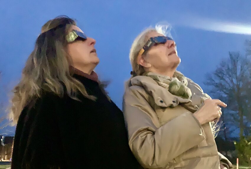 Tiverton residents Ellen Snell, left, and Sarah Trobaugh model solar eclipse glasses outside the Tiverton Public Library in anticipation of the solar eclipse on Monday, April 8.&nbsp;&nbsp;