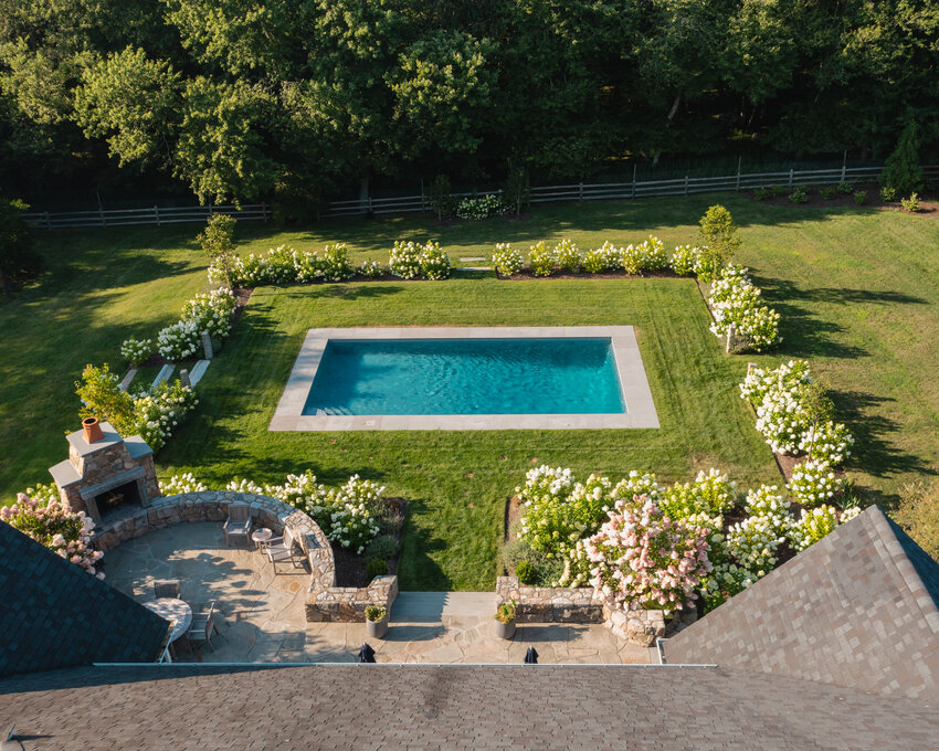 Simply designed and surrounded with limelight hydrangea, this pool was set on axis to a bench on the opposite&nbsp;side of the yard and nestled next to the existing&nbsp;upper terrace and fireplace for a convenient walk-out to this one-of-a-kind space.