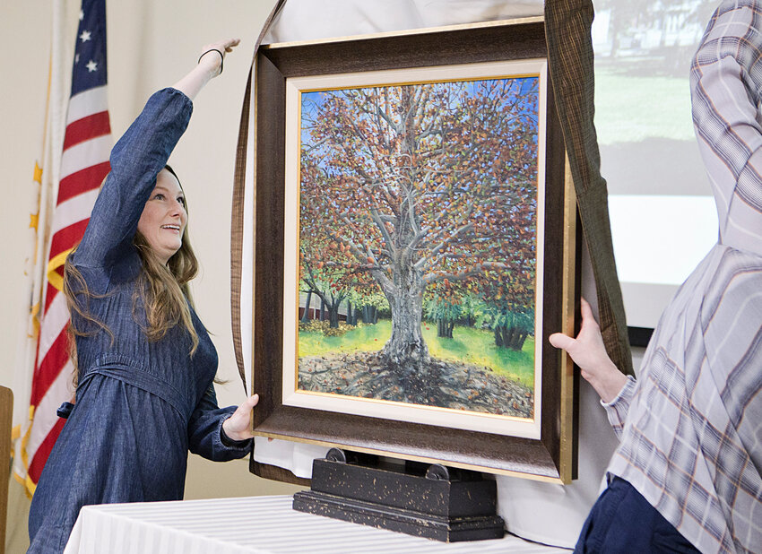 Artist Meg Voyer unveils her painting of Weaver Library's Copper Beech tree during a ceremony, Wednesday, April 24, during a reception held at the branch.